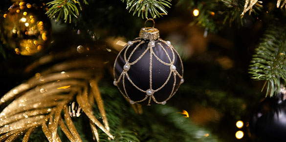 Schwarze Christbaumkugel mit goldenem Glitzermuster