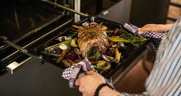 Backblech mit Essen in einen Neff Backofen schieben